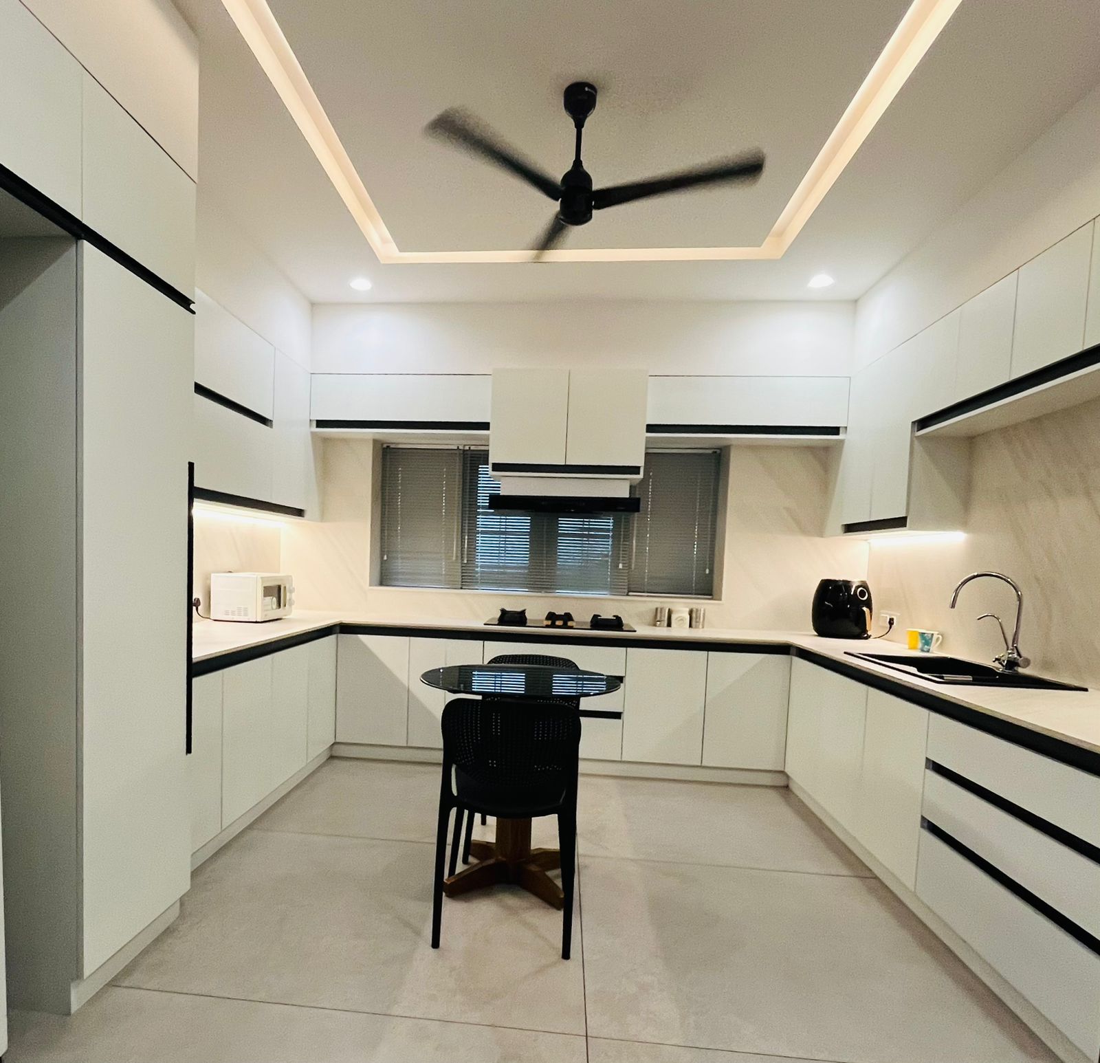 Bright long modular kitchen concept with black counter and storage cabinets